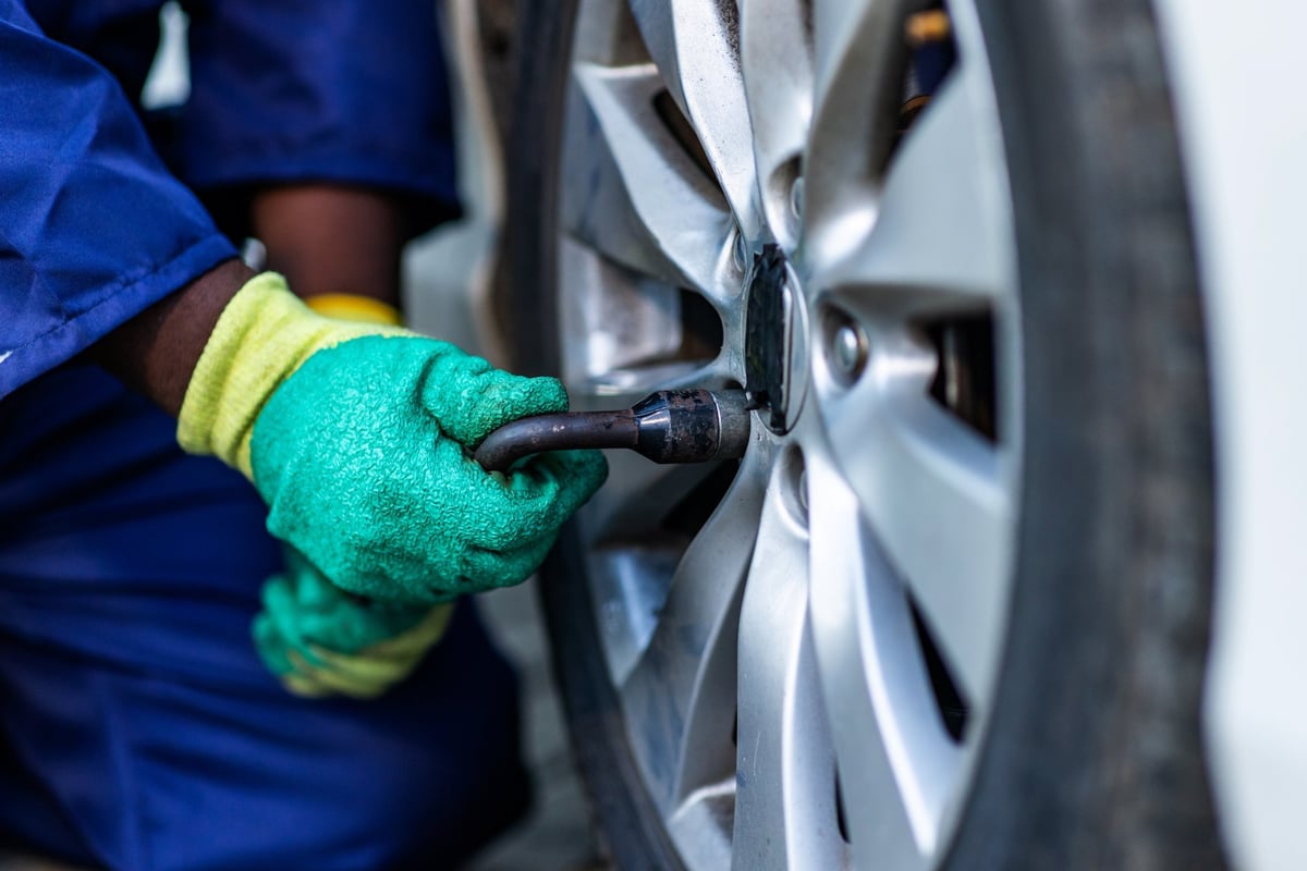 Mechanic's hands changing a car tire in the workshop